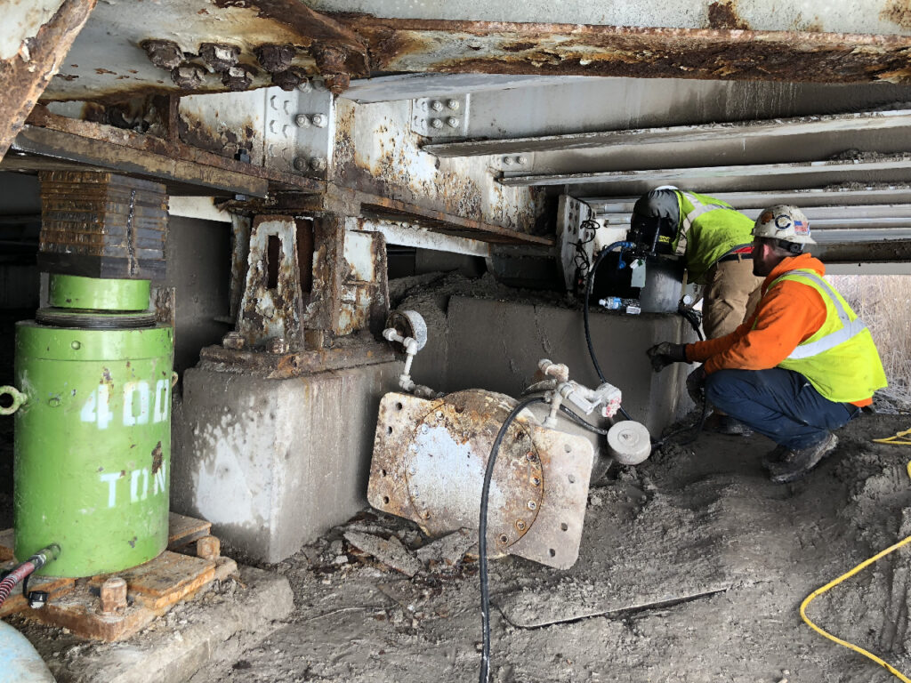 LGH industrial hydraulic ram jack, lifting a bridge, powered by a hydraulic pump.