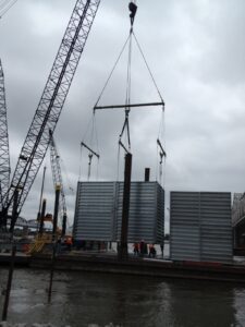 A jobsite photo, demonstrating modular spreader beams and a tri-link rigging sling triangle plate from LGH.