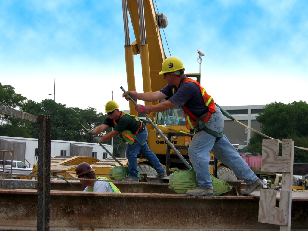 A jobsite photo of construction workers using a Tractel Griphoist rental from LGH to hoist a load.