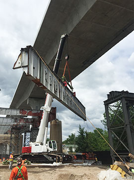 A crane lifting a section of a bridge using rigging and lifting equipment from LGH.