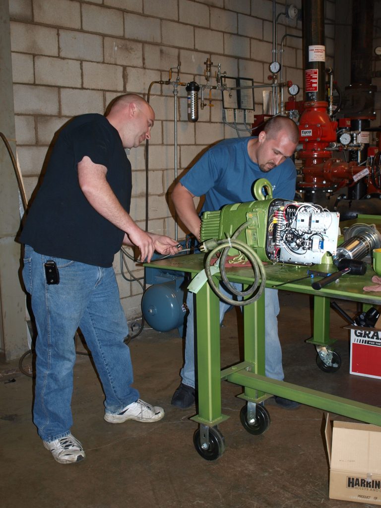 2 men participate in a hands-on training experience at LGH