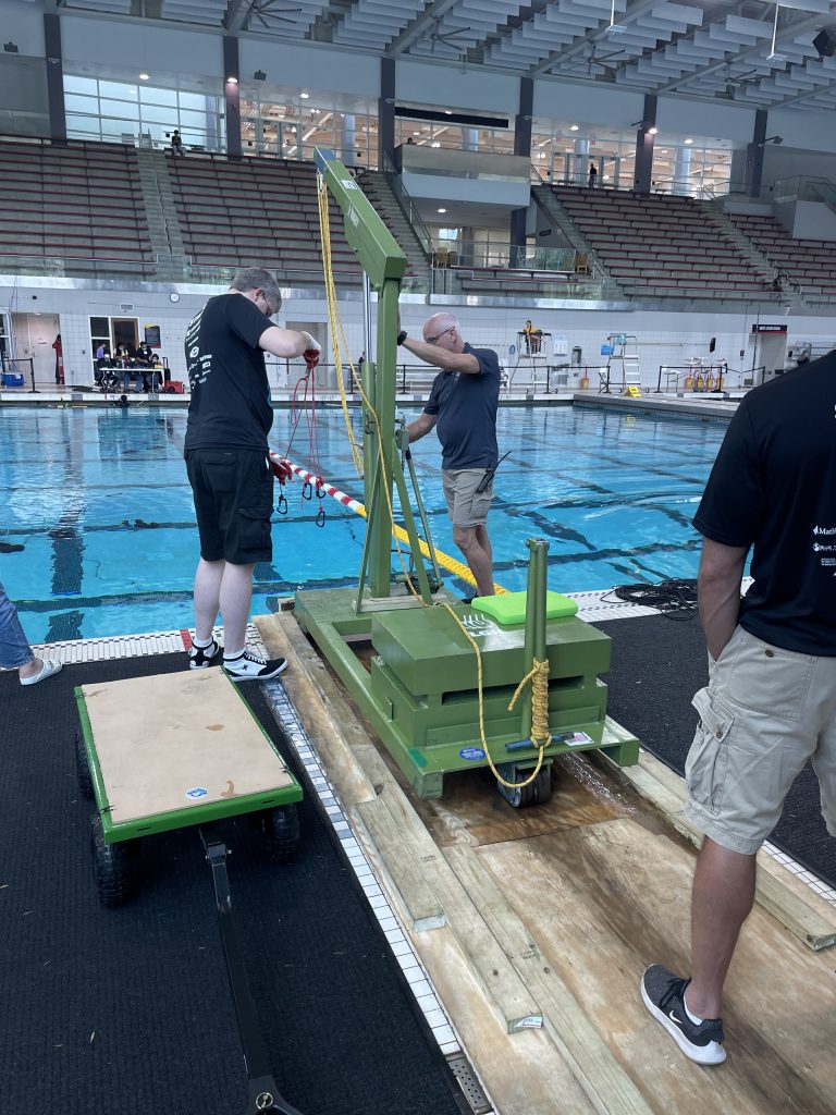 an lgh floor crane is used to lower an auv into the pool for the annual robosub event 